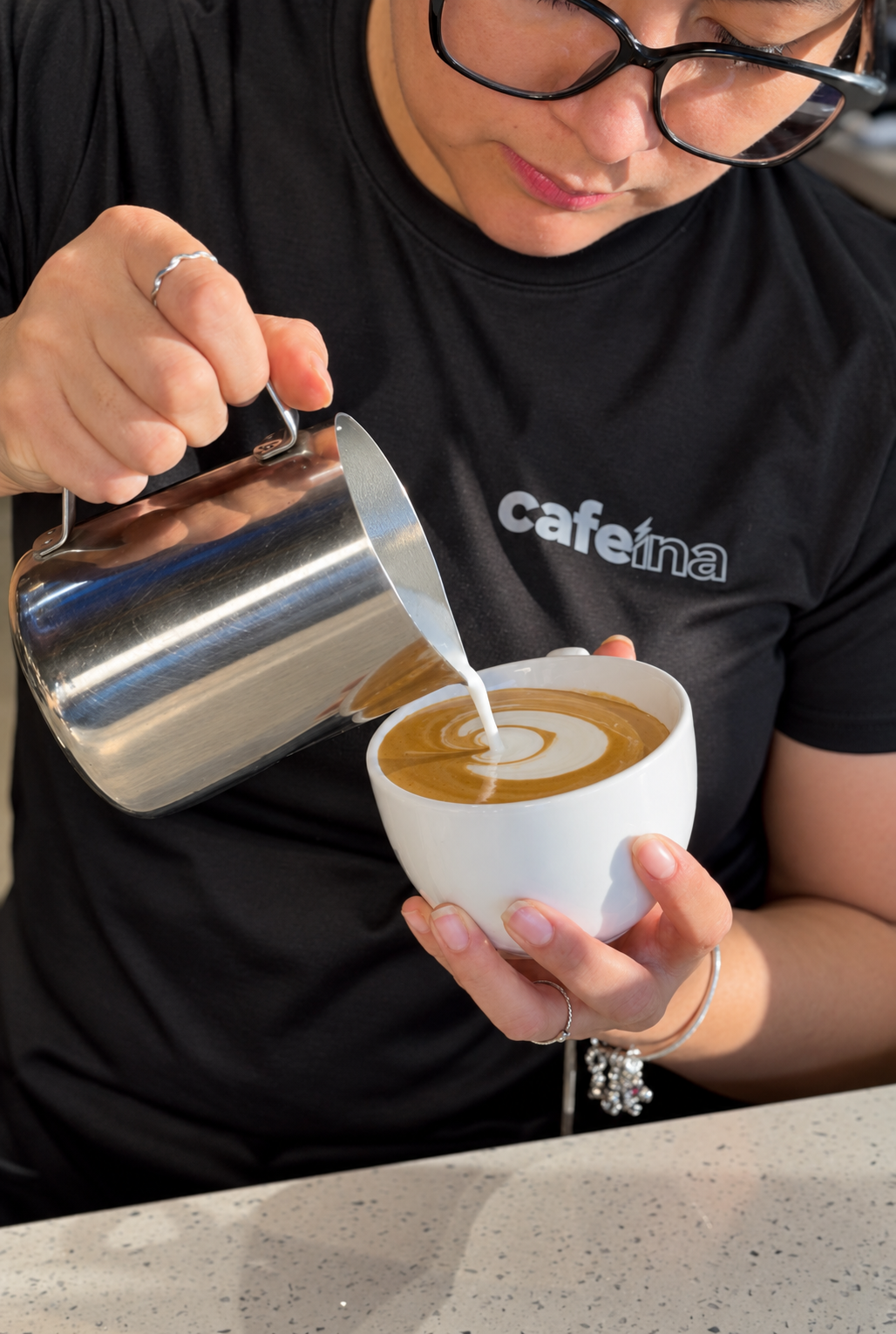 Barista de Cafe&iacute;na preparando arte latte